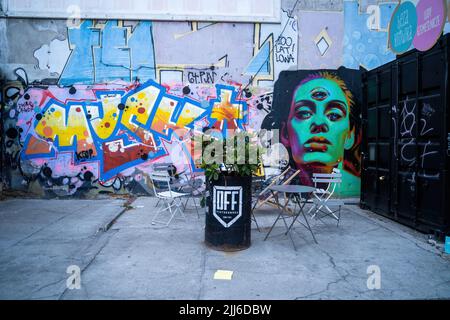 Lodz, Poland - July 08, 2022: A colorful street art graffiti next to a food truck in the city center Stock Photo