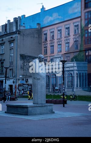 Lodz, Poland - July 08, 2022: Monument to Leon Schillerin at alley of Leon Schiller against architecture during night Stock Photo