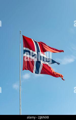 Shot of the flag of Norway against the blue cloudy sky Stock Photo - Alamy