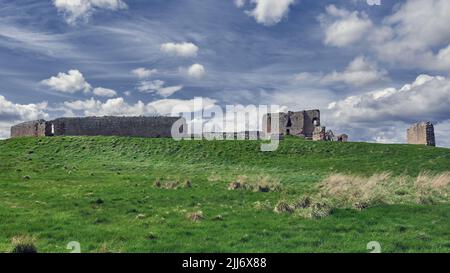 Spectacular view of ruins of Duffus Castle located in green valley on grassy hill near Elgin Moray, Scotland under blue cloudy sky Stock Photo