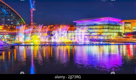 Darling Harbour Coockle bay in Sydney city at Vivid Sydney light show after sunset with colourful water fountain floating on Harbour. Stock Photo