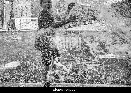 New York, New York, USA. 23rd July, 2022. Children play in the spray from the fire hydrant in the Bronx section of New York. New York temps reached the upper 90's with the heatwave expected to soar three the weekend. (Credit Image: © Brian Branch Price/ZUMA Press Wire) Stock Photo