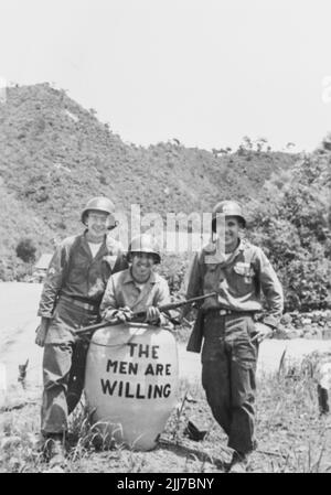 United States Army Troups during the Korean War - Circa 1952. Posing in front of a container labeled 'The Men Are Willing' at camp. From the collection of Henry G. Shebley Stock Photo