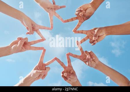 Youre the brightest star there is. a group of unrecognizable people making a star shape with their fingers. Stock Photo