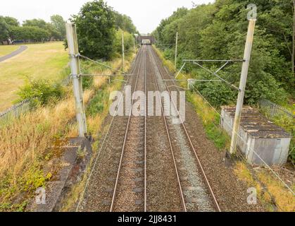 train tracks at longport station going of to the distance towards stoke on trent showing the Overhead line equipment shot from above Stock Photo