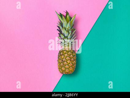 Top close up view ripe pineapple isolated on green purple flat-lay background. Studio creative fruit product photography concept Stock Photo