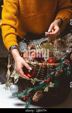 Young Woman with a Box Choosing Christmas Decorations in a Baske Stock Photo