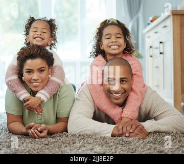 I genuinely love every moment I get to spend with my family. a young couple bonding their their two children at home. Stock Photo
