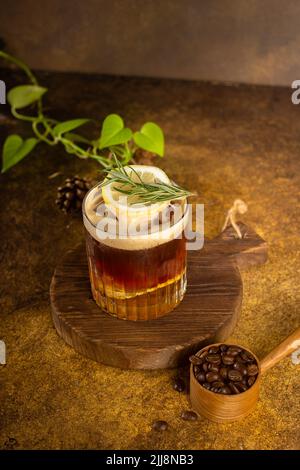 iced coffee with lemon sparkling water on rustic coaster and with rosemary on top Stock Photo