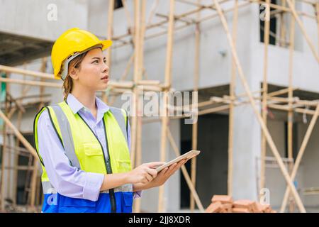 Engineer Construction Builder woman worker confident smart working in construction looking home build project. Stock Photo