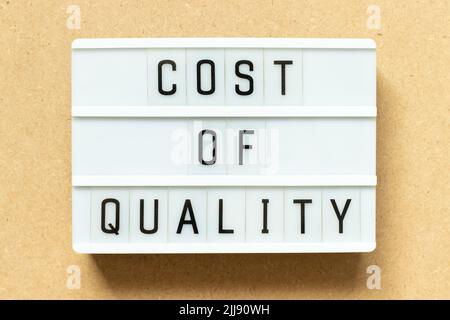 Lightbox with word cost of quality on wood background Stock Photo