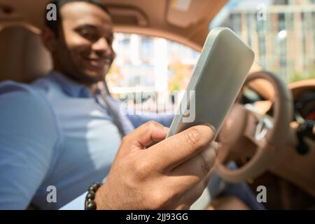 Driver using his cellphone during car trip Stock Photo