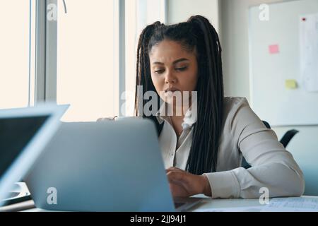 Concentrated design professional using her laptop in workplace Stock Photo