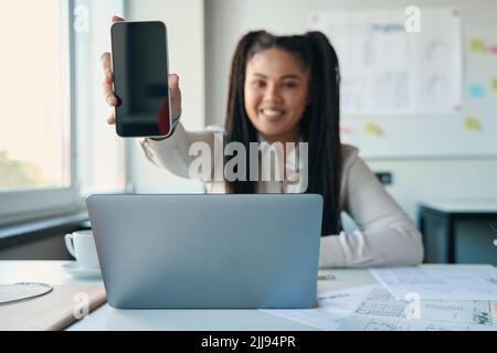 Female architect demonstrating her smartphone before camera Stock Photo