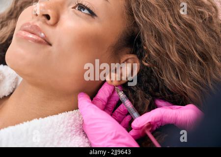 Young woman receives botulinum toxin injections in a cosmetology clinic Stock Photo