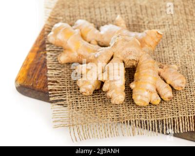 Whole ginger roots on dark wooden background Stock Photo