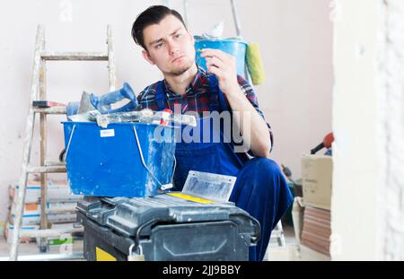 Worker looking for necessary tool in toolbox Stock Photo