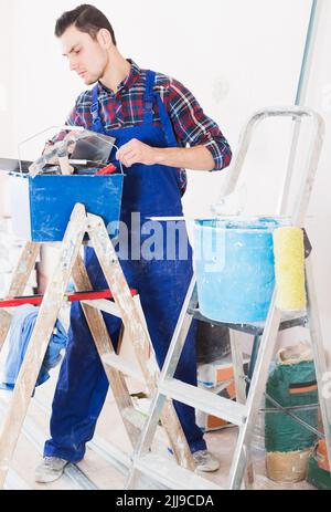 Worker looking for necessary tool in toolbox Stock Photo