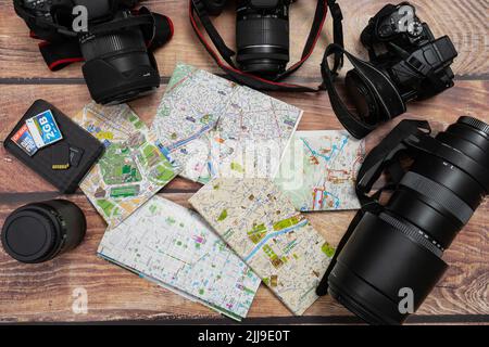 City maps next to cameras and passport on a wooden table. Concept of vacations, travels, travelers, Copy space. Stock Photo