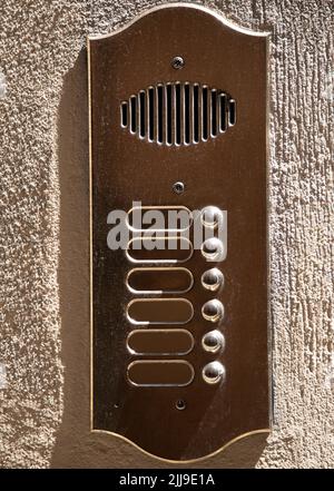 Weathered Brass Panel With Six Doorbells And Speaker Stock Photo