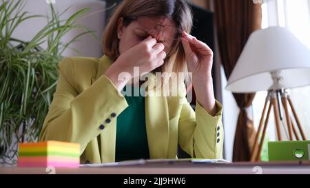Tired office manager sitting at workplace in office Stock Photo