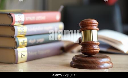 Wooden judge gavel on sounding block and stack of law books Stock Photo