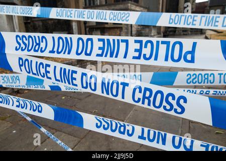 Police Line Do Not Cross tape barrier, typically placed around a crime scene by police officers or scene of crime officer / crimes officers. UK.(131) Stock Photo