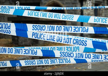 Police Line Do Not Cross tape barrier, typically placed around a crime scene by police officers or scene of crime officer / crimes officers. UK.(131) Stock Photo