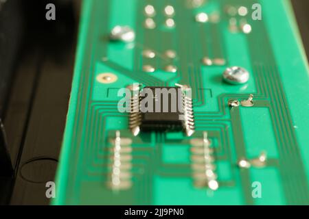Close up of an electronic component on a green circuit board with deep bokeh Stock Photo