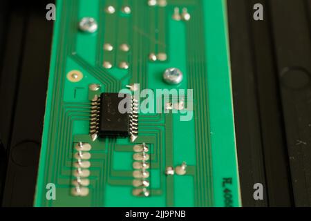 Close up of an electronic component on a green circuit board with deep bokeh Stock Photo