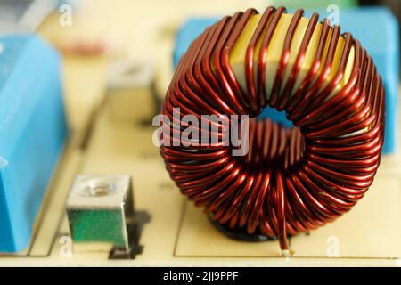 Coil electronic on printed circuit board detail. Inductor with copper wire, isolation transformer on PCB. Stock Photo