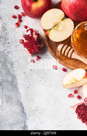 Rosh Hashanah. Pomegranate, apples and honey traditional products for celebration on rustic grey background. Jewish Autumn Rosh Hashana celebration. J Stock Photo