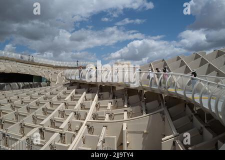 Seville, Spain -- June 3, 2022. A wide angle horizontal photo of tourists walking along the curved and fenced-in path at the top of 'The Mushroom' in Stock Photo