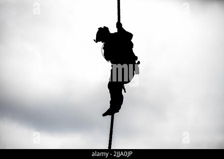 U.S. Army Special Operations Soldiers conduct fast rope insertion training aboard a Black Hawk (UH-60) helicopter operated by pilots with the 8-229 Assault Helicopter Battalion, 244th Expeditionary Air Combat Brigade, during Operation Viking at Joint Base Cape Cod, Mass., July 18, 2022. Operation Viking is an intense joint task force exercise designed to prepare Soldiers with realistic training simulating deployment of civil affairs units in direct support of contigency operation in Africa. Stock Photo