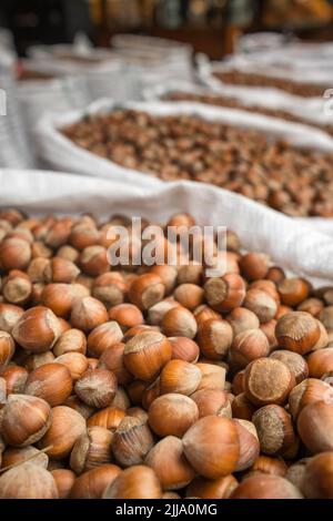 Fresh hazelnuts in shells for sale in outdoor food market. Stock Photo