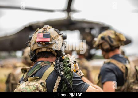 U.S. Army Special Operations Soldiers conduct fast rope insertion training aboard a Black Hawk (UH-60) helicopter operated by pilots with the 8-229 Assault Helicopter Battalion, 244th Expeditionary Air Combat Brigade, during Operation Viking at Joint Base Cape Cod, Mass., July 18, 2022. Operation Viking is an intense joint task force exercise designed to prepare Soldiers with realistic training simulating deployment of civil affairs units in direct support of contigency operation in Africa. Stock Photo