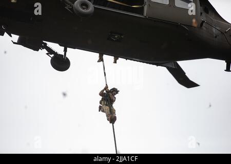 U.S. Army Special Operations Soldiers conduct fast rope insertion training aboard a Black Hawk (UH-60) helicopter operated by pilots with the 8-229 Assault Helicopter Battalion, 244th Expeditionary Air Combat Brigade, during Operation Viking at Joint Base Cape Cod, Mass., July 18, 2022. Operation Viking is an intense joint task force exercise designed to prepare Soldiers with realistic training simulating deployment of civil affairs units in direct support of contigency operation in Africa. Stock Photo