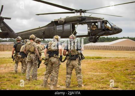 U.S. Army Special Operations Soldiers conduct fast rope insertion training aboard a Black Hawk (UH-60) helicopter operated by pilots with the 8-229 Assault Helicopter Battalion, 244th Expeditionary Air Combat Brigade, during Operation Viking at Joint Base Cape Cod, Mass., July 18, 2022. Operation Viking is an intense joint task force exercise designed to prepare Soldiers with realistic training simulating deployment of civil affairs units in direct support of contigency operation in Africa. Stock Photo