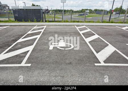 Reserved disable parking sign on the asphalt road surface. Stock Photo