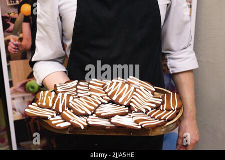 the chef holds a tray of ginger cookies with icing Stock Photo