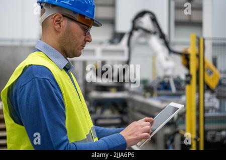 Portrait of engineer adjusting controls with tablet Stock Photo