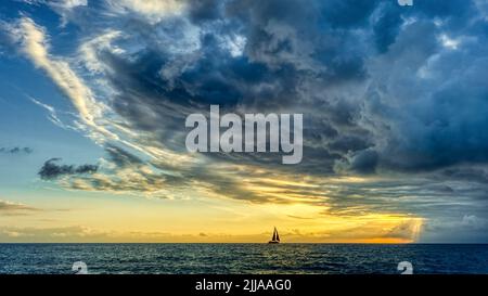 A Storm Is Looming Overhead As A Small Boat Moves Toward The The Shining Light Stock Photo