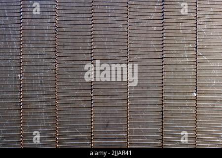 Selective focus and close up view of dirty rectangular metal wire mesh curtain with spiderweb between the gap. Stock Photo