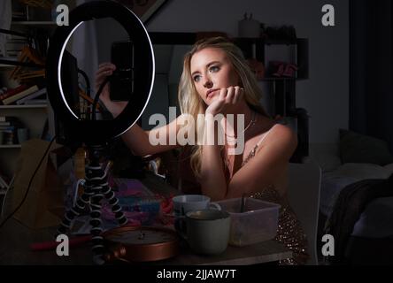 Setting up for a shoot. an attractive young female influencer recording content her for her channel. Stock Photo