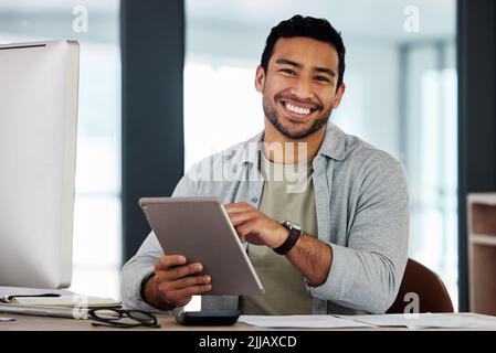 No one could do what I do. a young businessman using his digital tablet. Stock Photo