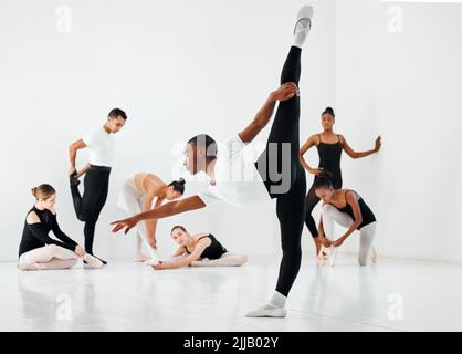 As a dancer, youve gotta be flexible. Full length shot of a diverse group of ballet students rehearsing in their dance studio. Stock Photo