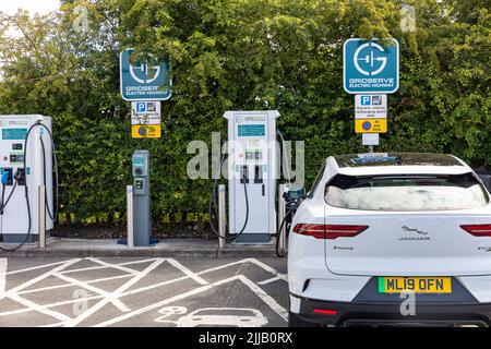 Electric Jaguar I-pace in white being charged at a motorway service station in England using Gridserve charging network.England,UK Stock Photo