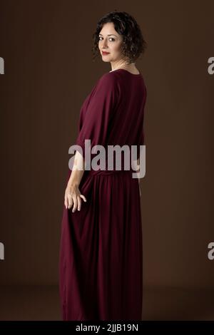A 1920s woman wearing a dark red dress against a studio backdrop Stock  Photo - Alamy