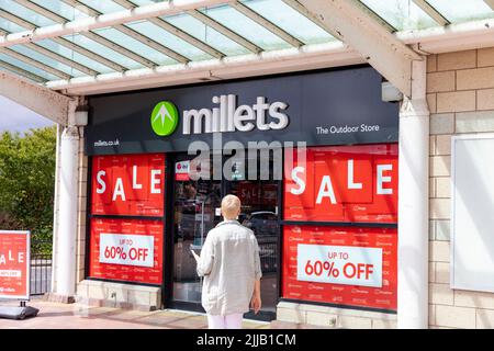 Millets Outdoor clothing store in Bury Lancashire, summer sale in 2022, with model released fifties woman entering the store,England,United Kingdom Stock Photo