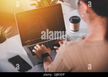 Web application development. programmer woman writing program code sitting at workplace in office, software developer hands coding HTML programming wi Stock Photo